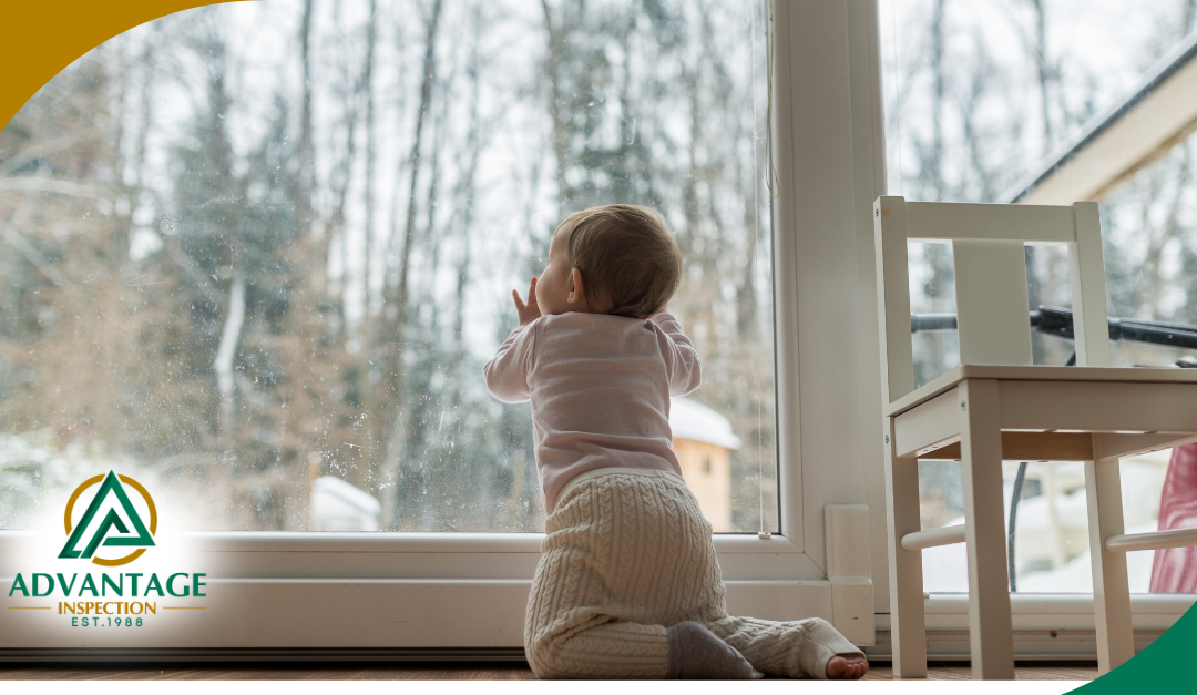 A baby looks out a large glass door at a snowy winter scene, symbolizing warmth and safety at home.