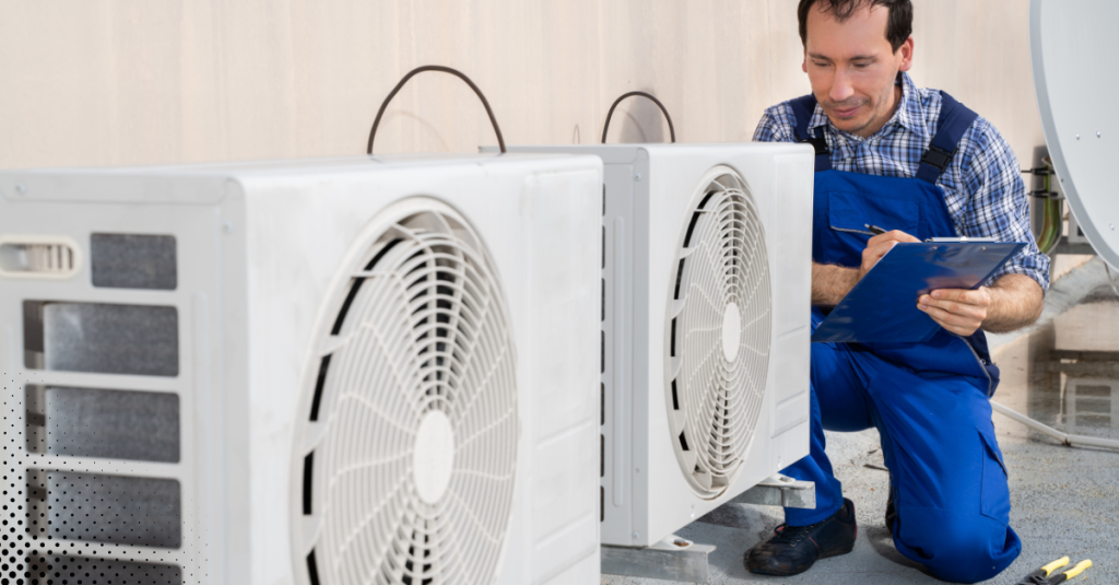 Technician inspecting outdoor HVAC units with a clipboard.